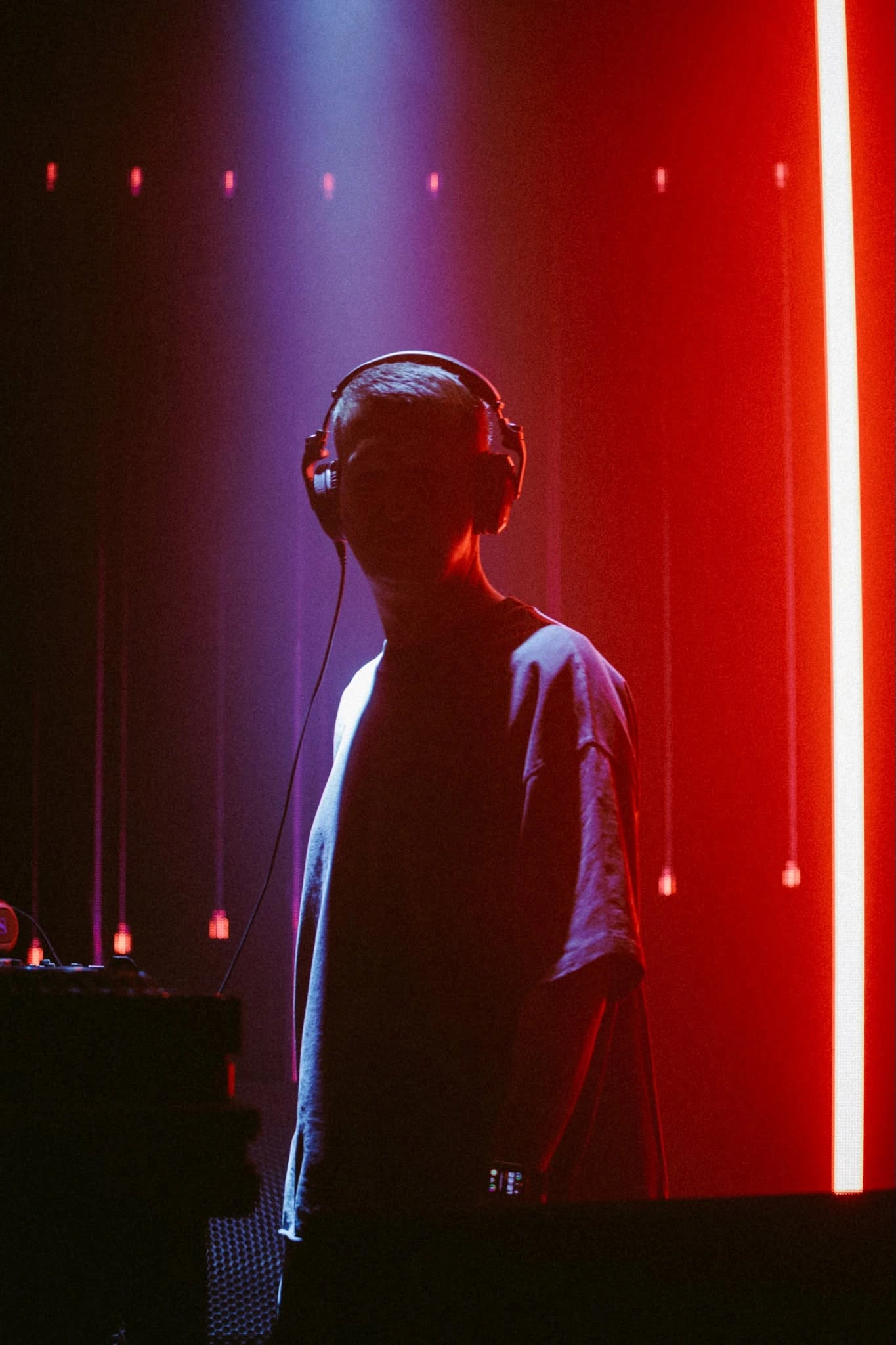Arnas D silhouetted against a vertical red stage light