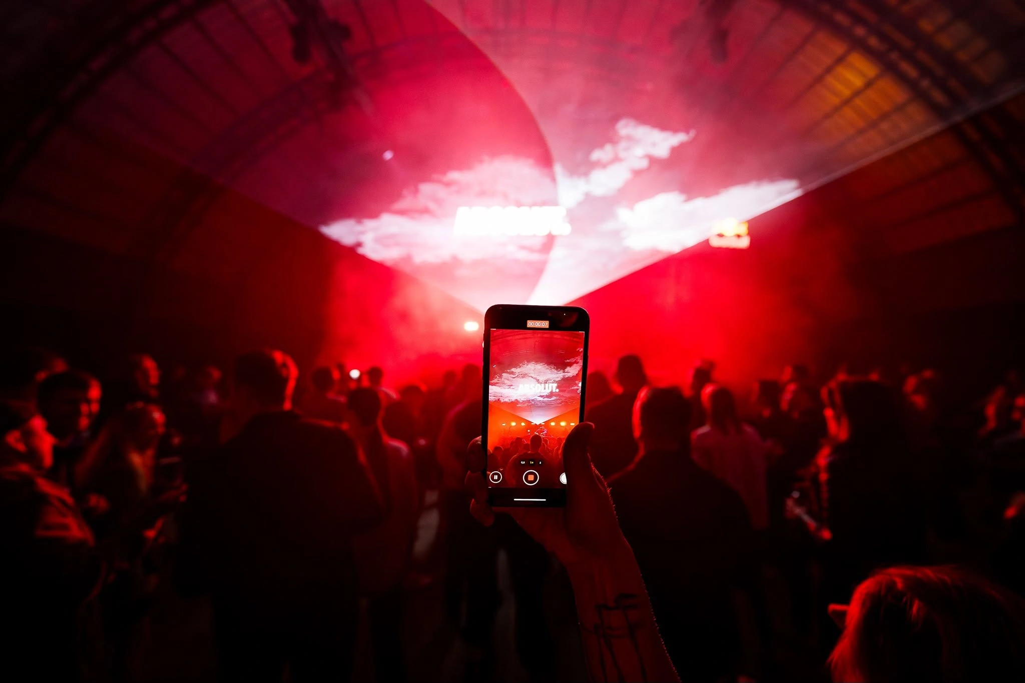 A phone capturing red lights over the crowd
